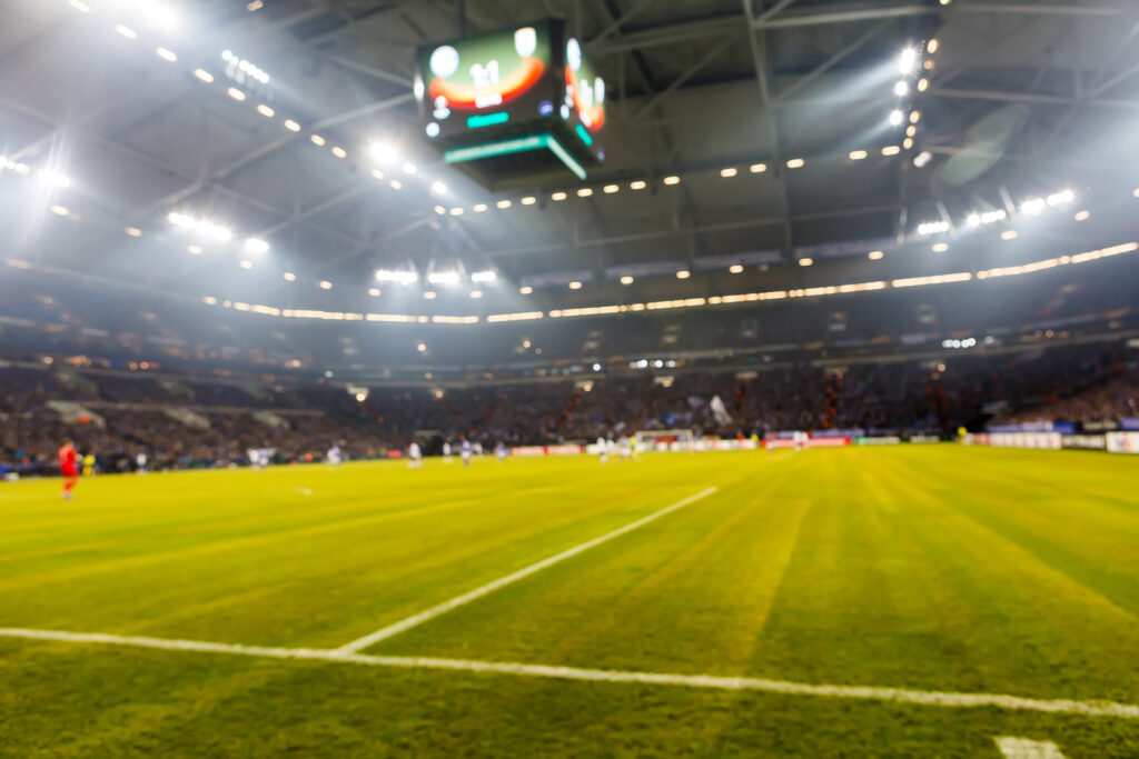 Blurred field with lights and full of spectators at the stadium one step at a sporting event